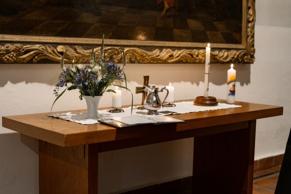 Ein Wasskrug und eine Taufkerze stehen auf dem Altar