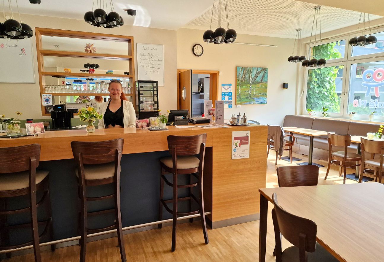 Tresen vom Café Pi8. Eine Frau steht dahinter