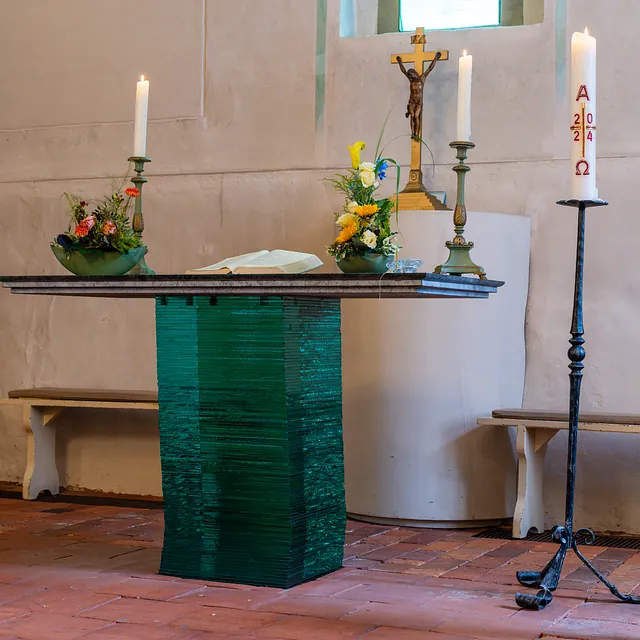 Kirchenraum mit grünem Altar, Altarkerzen und Osterkerze