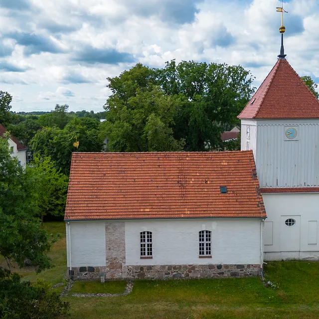 Luftaufnahme der Dorfkirche Alt-Staaken mit Turm, umgeben von Bäumen