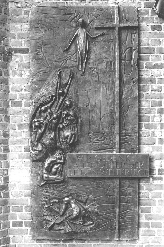 Bronzerelief der Ehrentafel von Heinz Spilker (1964) zum Gedenken an die Opfer beider Weltkriege an der Klinkerwand neben dem Eingang