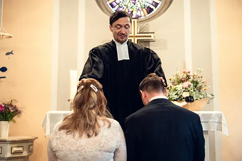 Pfarrer segnet das Brautpaar vor dem Altar (aufgenommen in der Dorfkirche Alt-Kladow)