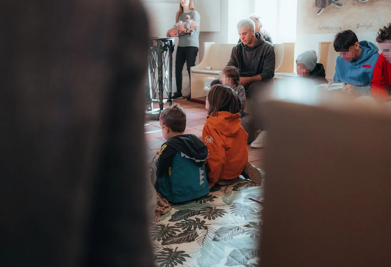 Mehrere Kinder und erwachsene sitzen im Gottesdienst
