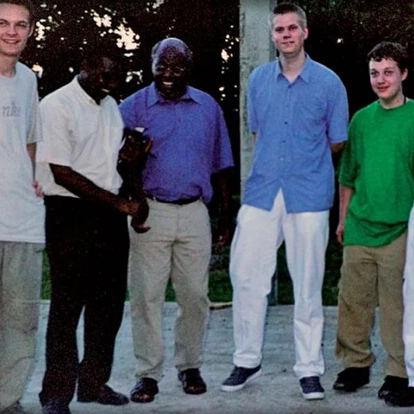 Fünf Männer stehen im Freien nebeneinander und schauen in die Kamera.