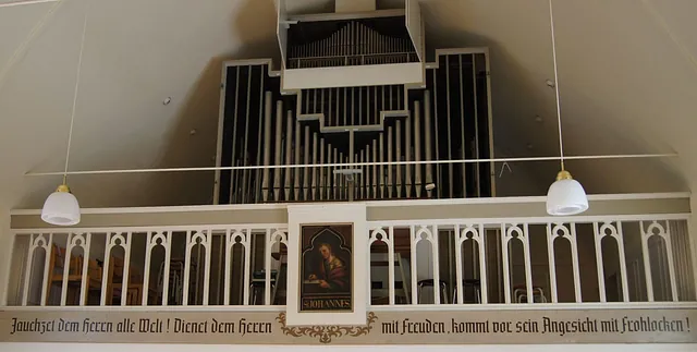 Orgelempore mit der Weißenborn-Orgel von 1959 hinter einer weißen Holzbrüstung mit Bibelvers